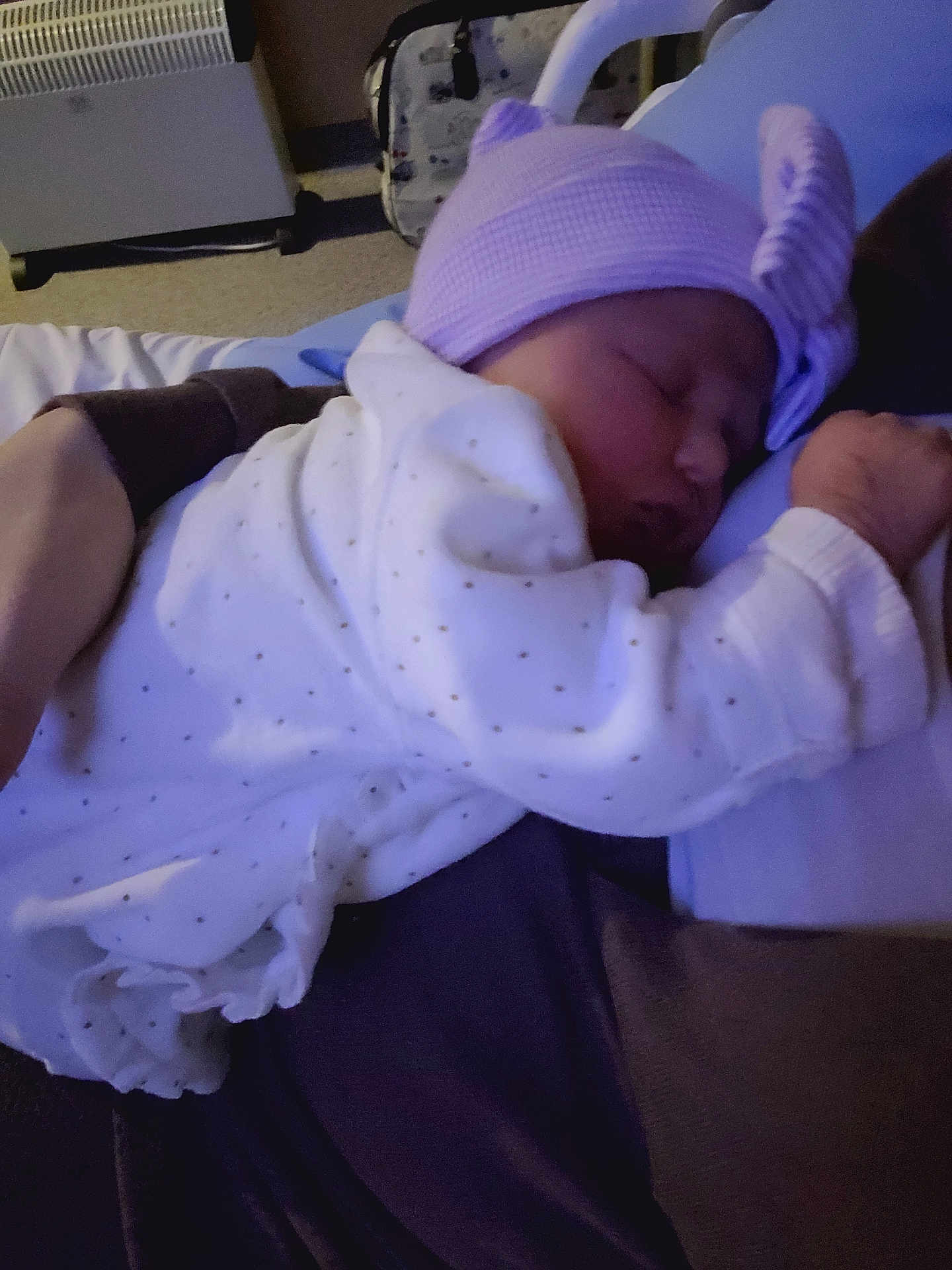 Amélia participe au concours pour gagner de l'argent avec cette photo : arm, baby, bed, blanket, bow, child, cozy, dots, hand, hat, heater, indoor, infant, person, purple, rest, sleeping, soft_lighting, suitcase, white_clothing