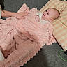 Amélia a rejoint le concours — aidez-le/la à gagner de superbes lots ! baby, blanket, checkered, child, comfort, couch, cozy, cute, fabric, grey, hand, indoor, infant, person, pillow, pink, resting, smile, soft, warm