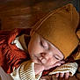 baby, sleeping, hat, brown, orange, clothing, hand, face, peaceful, infant, portrait, closeup, wood, texture, soft_light, warm_colors, resting, cute, child, cozy