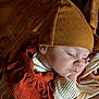 baby, sleeping, hat, clothing, infant, face, peaceful, soft_light, warm_colors, closeup, portrait, cozy, hand, newborn, child, cute, resting, texture, fabric, skin