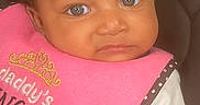 Annaniyah is registered to the contest to win money with this photo: animal_print, baby, bow, car_seat, child, closeup, clothing, cute, expression, eyes, face, headband, indoors, infant, person, pink_bib, portrait, seat_belt, sitting, young_child