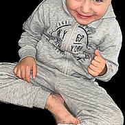 Kais a rejoint le concours — aidez-le/la à gagner de superbes lots ! child, boy, smile, gray_tracksuit, sitting, barefoot, happy, portrait, casual_clothing, playful, young, person, childhood, cute, indoors, relaxed, fun, hair, face, skin