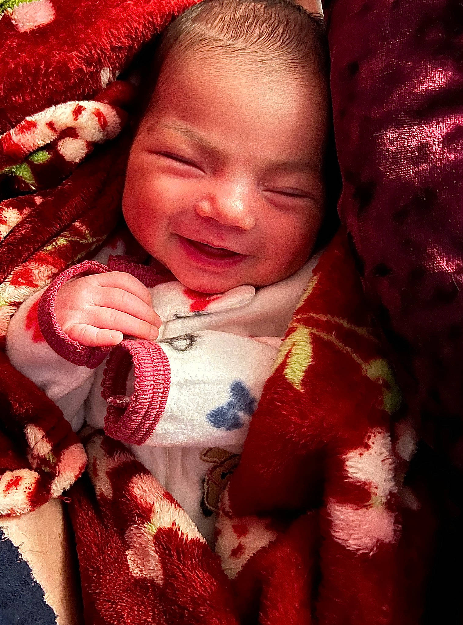 Amora is registered to the contest to win money with this photo: baby, baby_toddler_clothing, cheek, child, close_up, event, face, happy, human_body, linens, lip, magenta, nose, pattern, person, pink, plaid, red, skin, smile