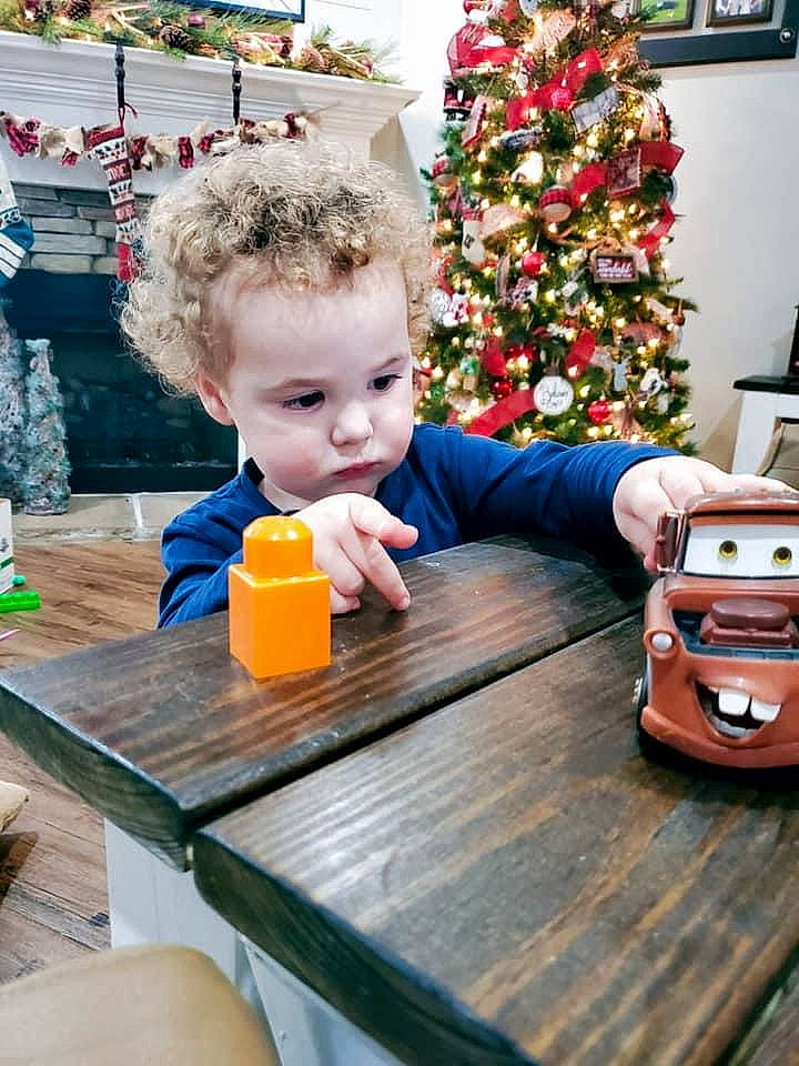 Jaxyn is registered to the contest to win money with this photo: baby, child, christmas, christmas_decoration, christmas_eve, christmas_ornament, christmas_tree, conifer, display_device, ear, holiday, holiday_ornament, ornament, person, picture_frame, play, table, toddler, toy, varnish