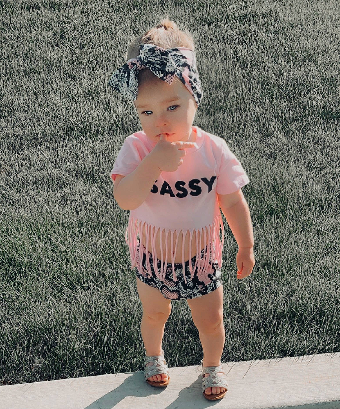 Kenzley is registered to the contest to win money with this photo: baby_toddler_clothing, cool, eyewear, face, footwear, grass, hair, happy, head, headwear, jewellery, neck, person, sleeve, sportswear, street_fashion, style, thigh, toddler, trunk