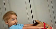 Cody is registered to the contest to win money with this photo: activity, blue_shirt, boy, cabinet, child, expression, floor, fun, furniture, hair, home, indoor, kid, motion_blur, person, play, rocking_horse, smile, toy, young