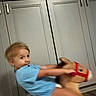 activity, blue_shirt, boy, cabinet, child, expression, floor, fun, furniture, hair, home, indoor, kid, motion_blur, person, play, rocking_horse, smile, toy, young