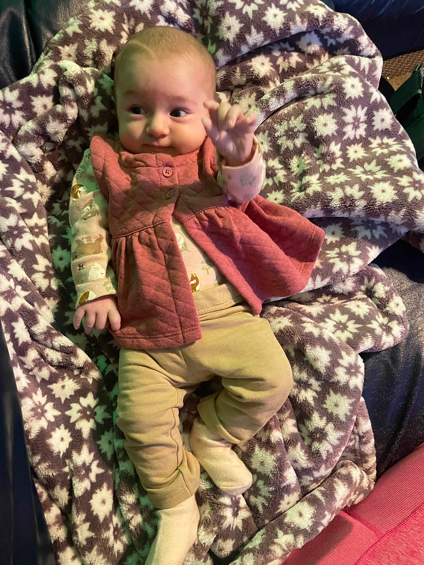 Madeline joined the competition — help win amazing prizes! baby, infant, blanket, patterned_blanket, pink_vest, beige_pants, socks, lying_down, indoor, cute, young_child, soft_texture, cozy, warm_clothing, small_hands, face, curious, comfort, resting, furniture