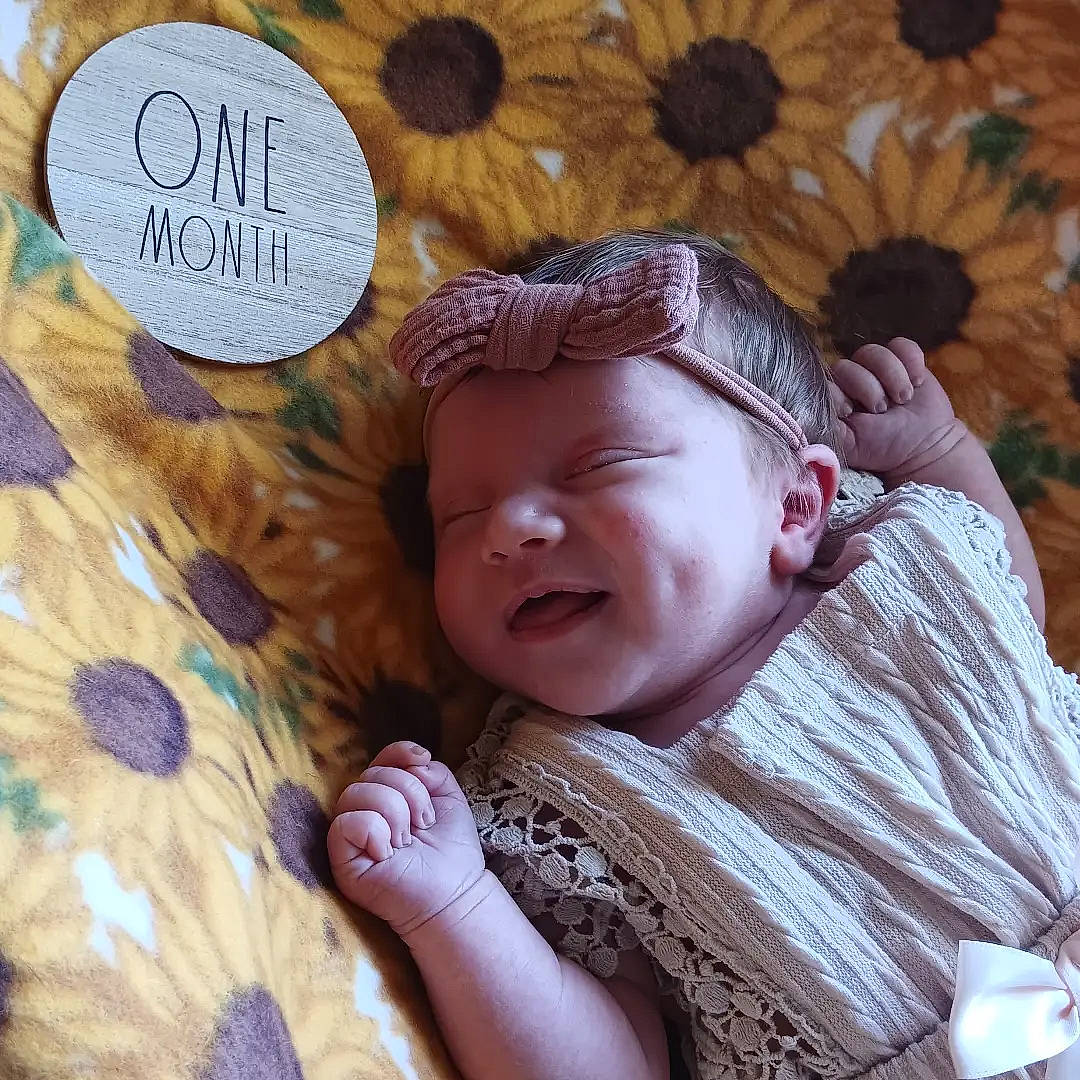 Josephine joined the competition — help win amazing prizes! baby, baby_sleeping, baby_toddler_clothing, bedtime, cheek, child, comfort, finger, gesture, grass, happy, interaction, linens, pattern, person, sitting, skin, smile, textile, toddler