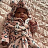 baby, infant, pink, robe, leopard_print, hood, ears, bed, quilt, blanket, soft, cute, cozy, clothing, child, person, lying_down, indoor, portrait, warm