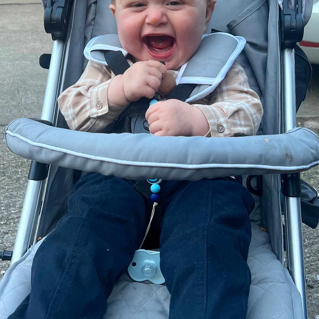 Noah is registered to the contest to win money with this photo: baby, city, clothing, coat, face, footwear, happy, head, jacket, jeans, pants, person, photography, portrait, road, sandal, shoe, street, stroller, urban