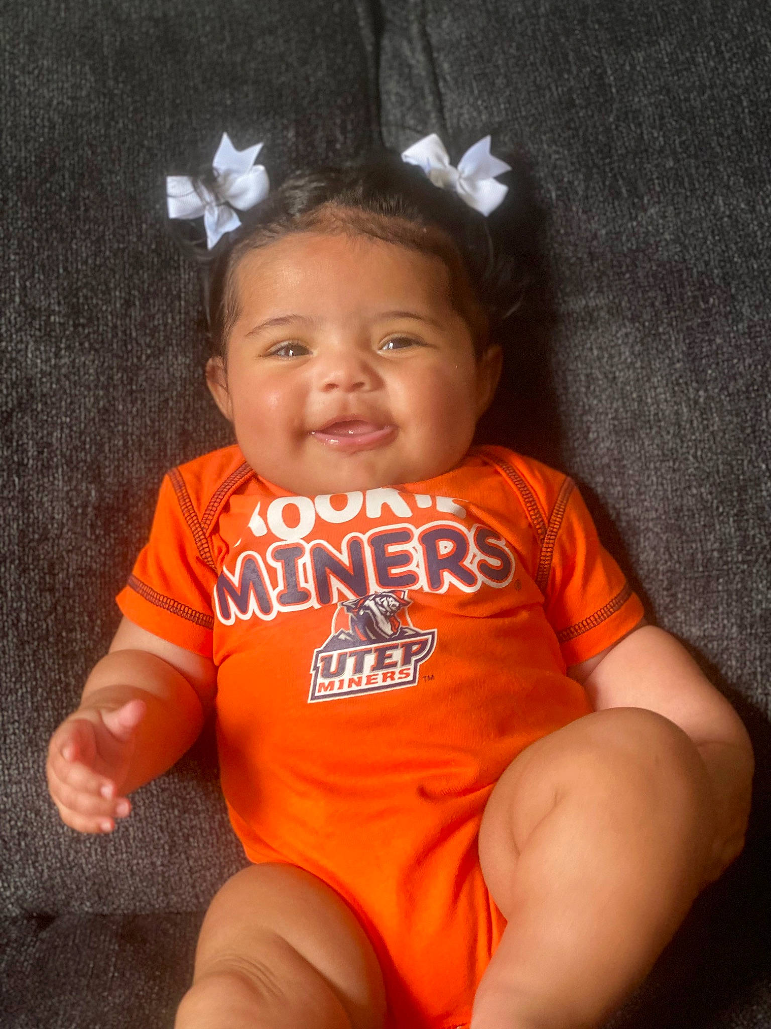 Nova is registered to the contest to win money with this photo: arm, baby, baby_toddler_clothing, cheek, child, eye, flash_photography, fun, happy, headpiece, human_leg, joy, nose, orange, person, skin, sleeve, smile, t_shirt, thigh