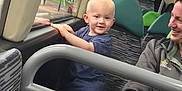 Carson joined the competition — help win amazing prizes! child, toddler, bus, window, seat, adult, woman, smile, holding, clothing, interior, public_transport, handrail, blue_shirt, jeans, blond_hair, patterned_seat, green_headrest, daylight, smiling