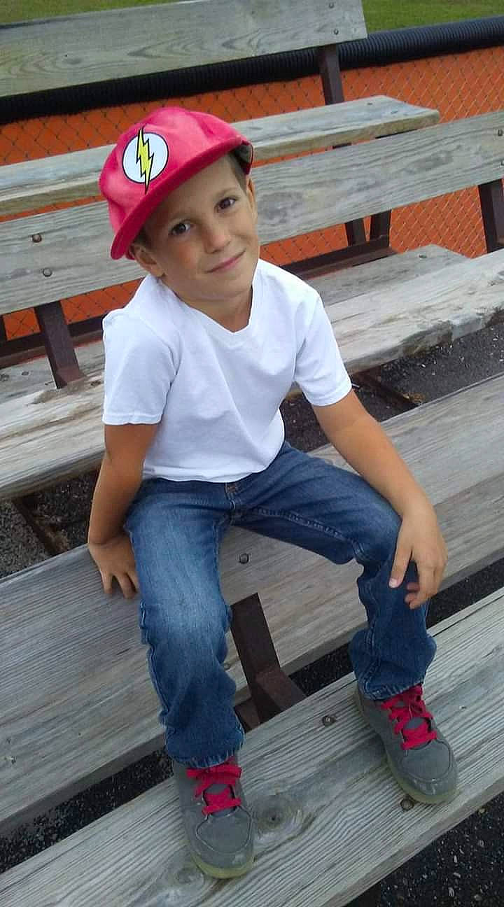 Zak is registered to the contest to win money with this photo: cap, child, child_model, denim, footwear, headgear, headwear, jeans, joy, leg, person, play, sitting, sun_hat, t_shirt, toddler, wood