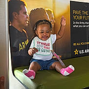 Ruemani joined the competition — help win amazing prizes! advertisement, army, bench, bib, braided_hair, child, footwear, happy, indoor, person, pink_socks, playful, poster, raising_hand, recruitment, shorts, sitting, smiling, toddler, white_shirt