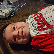 Braylen joined the competition — help win amazing prizes! baby, smiling, infant, blanket, clothing, red, white, striped, embroidery, face, head, cushion, baby_seat, floor, wooden_floor, indoor, person, portrait, child, cozy