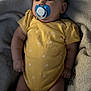 Aliyah joined the competition — help win amazing prizes! baby, infant, yellow_onesie, pacifier, blanket, soft_texture, lying_down, cute, child, skin, indoors, portrait, young_child, comfort, chubby, sleepwear, peaceful, small_hands, relaxed, closeup
