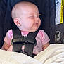 baby, infant, car_seat, sleeping, blanket, safety_harness, child, pink_clothing, face, peaceful, young, cute, indoors, head, resting, newborn, seat, comfort, strap, smile