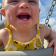 Willow joined the competition — help win amazing prizes! baby, child, swing, outdoor, smiling, yellow_dress, sky, chain, happy, face, teeth, sunlight, playground, summer, infant, person, cute, joy, fun, closeup