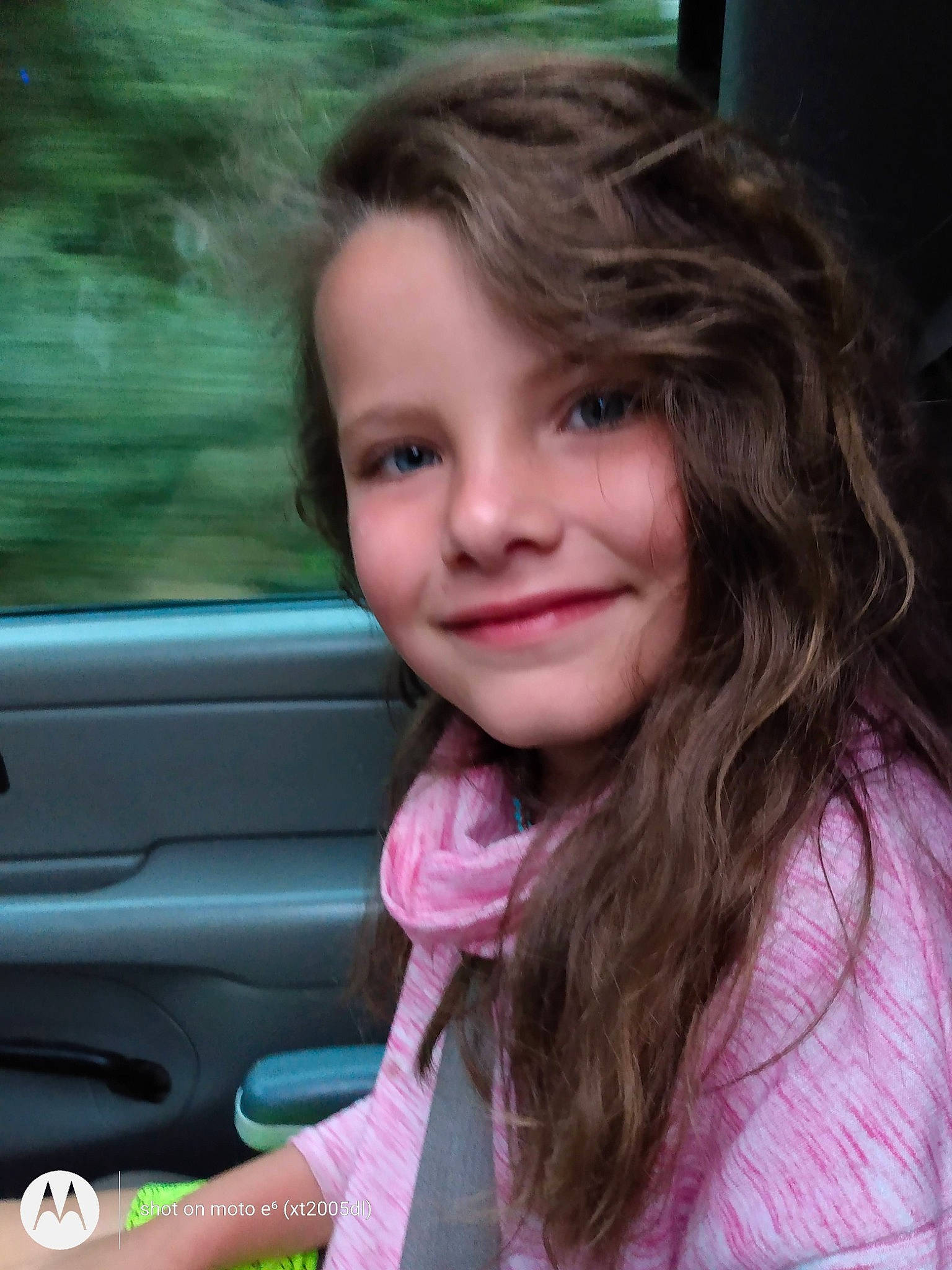 Maycee is registered to the contest to win money with this photo: automotive_mirror, car, cheek, chin, cool, eyebrow, eyelash, happy, iris, joy, lip, long_hair, mouth, nose, person, pink, skin, smile, standing, toddler