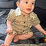 baby, bright_eyes, carpet, child, clothing, curious, cute, face, foot, furniture, hand, indoor, living_room, pattern, person, shirt, shorts, sitting, smiling, toy