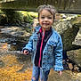 Séréna a rejoint le concours — aidez-le/la à gagner de superbes lots ! child, girl, denim_jacket, jeans, shoes, stream, water, rocks, bridge, outdoor, nature, smiling, standing, sunlight, hair, casual_clothing, forest, playful, happy, adventure