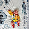 newborn, baby, sleeping, portrait, cowboy_costume, yellow_outfit, red_scarf, beanie, blanket, clouds, stars, toy_story, woody, indoor, lying_down, infant, peaceful, nursery, textile, photography
