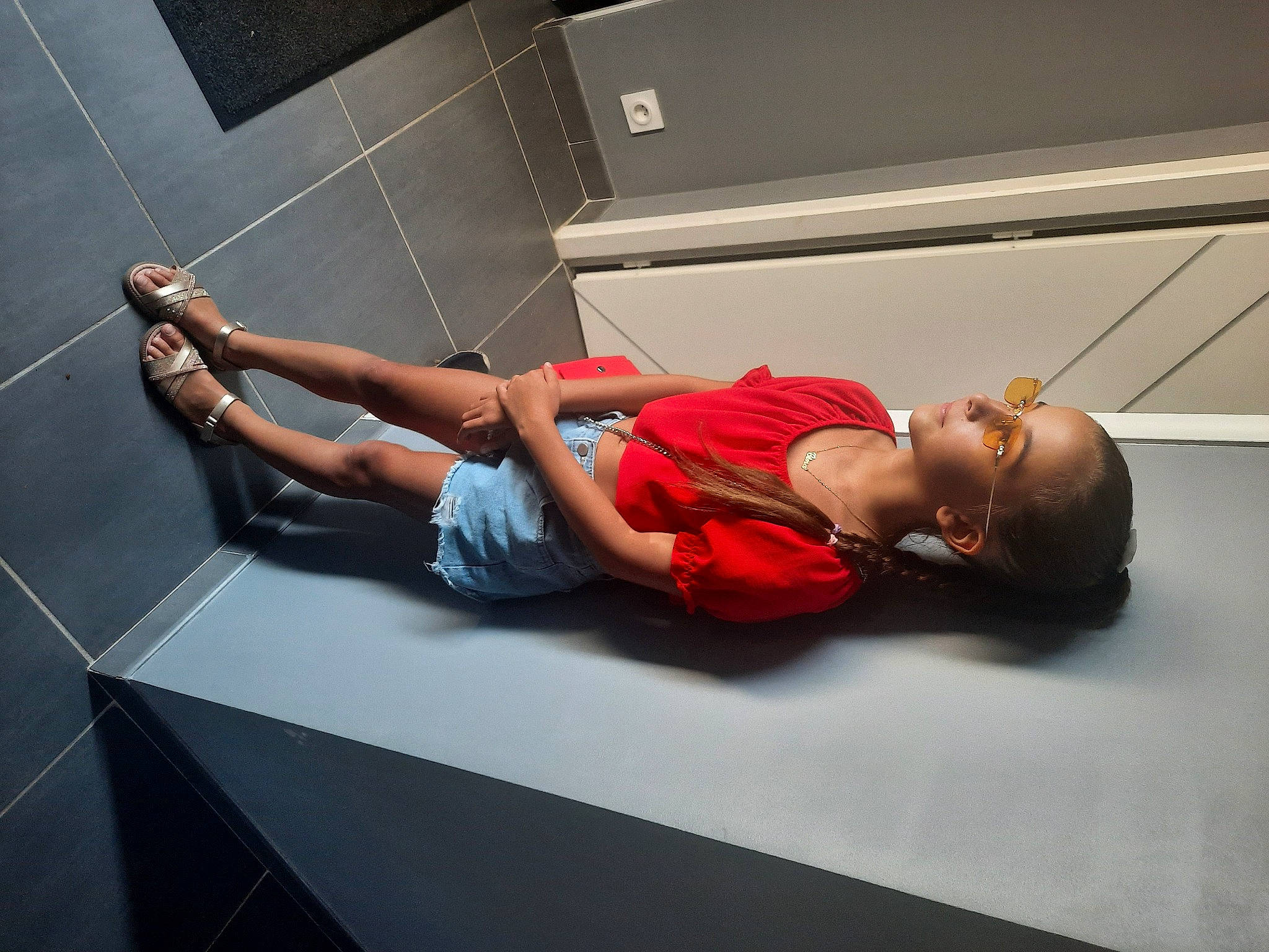 Gina participe au concours pour gagner de l'argent avec cette photo : abdomen, automotive_design, chest, comfort, elbow, event, flooring, fun, hat, human_leg, knee, leisure, performance_art, person, physical_fitness, room, sandal, shorts, sitting, thigh