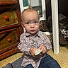 Atlas is registered to the contest to win money with this photo: baby, child, toddler, portrait, sitting, indoors, face, blue_eyes, wide_eyed, patterned_shirt, jeans, brush, wooden_dresser, basketball, mirror, cushion, floor, home, photography, cute