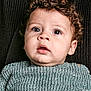 Mohamed is registered to the contest to win money with this photo: toddler, child, curly_hair, face, eyes, sweater, knitted, portrait, close_up, expression, cute, baby, young_child, person, indoor, cozy, skin, head, mouth, eyelashes