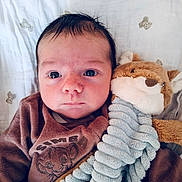 Marius participe au concours pour gagner de l'argent avec cette photo : baby, infant, newborn, face, eyes, blanket, stuffed_animal, plush_toy, toy, onesie, clothing, portrait, close_up, bedding, nursery, soft_toy, expression, lying_down, head, cute