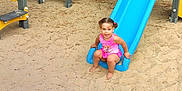 Stylia a rejoint le concours — aidez-le/la à gagner de superbes lots ! barefoot, blue, child, cute, fun, happy, outdoor, park, person, pink_clothing, play_equipment, playground, recreation, sand, slide, smiling, summer, toddler, toy, yellow