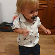 Santiago a rejoint le concours — aidez-le/la à gagner de superbes lots ! active, baby, blond_hair, cabinet, child, cute, floor, furniture, home, indoor, motion_blur, pacifier, person, shorts, smile, toddler, walking, white_shirt, wooden_floor, young_child