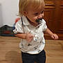 baby, blonde_hair, cabinet, casual_clothing, child, cute, furniture, home, indoor, motion, motion_blur, pacifier, person, portrait, shorts, toddler, walking, white_shirt, wooden_floor, young_child