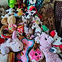 animal_toy, colorful, couch, cozy, cute, dog, donut, hidden_pet, indoor, moose, patterned_pillow, pillow, pink_bone, plush_toy, small_dog, soft_toys, stuffed_animal, toy_collection, treat_bag, unicorn