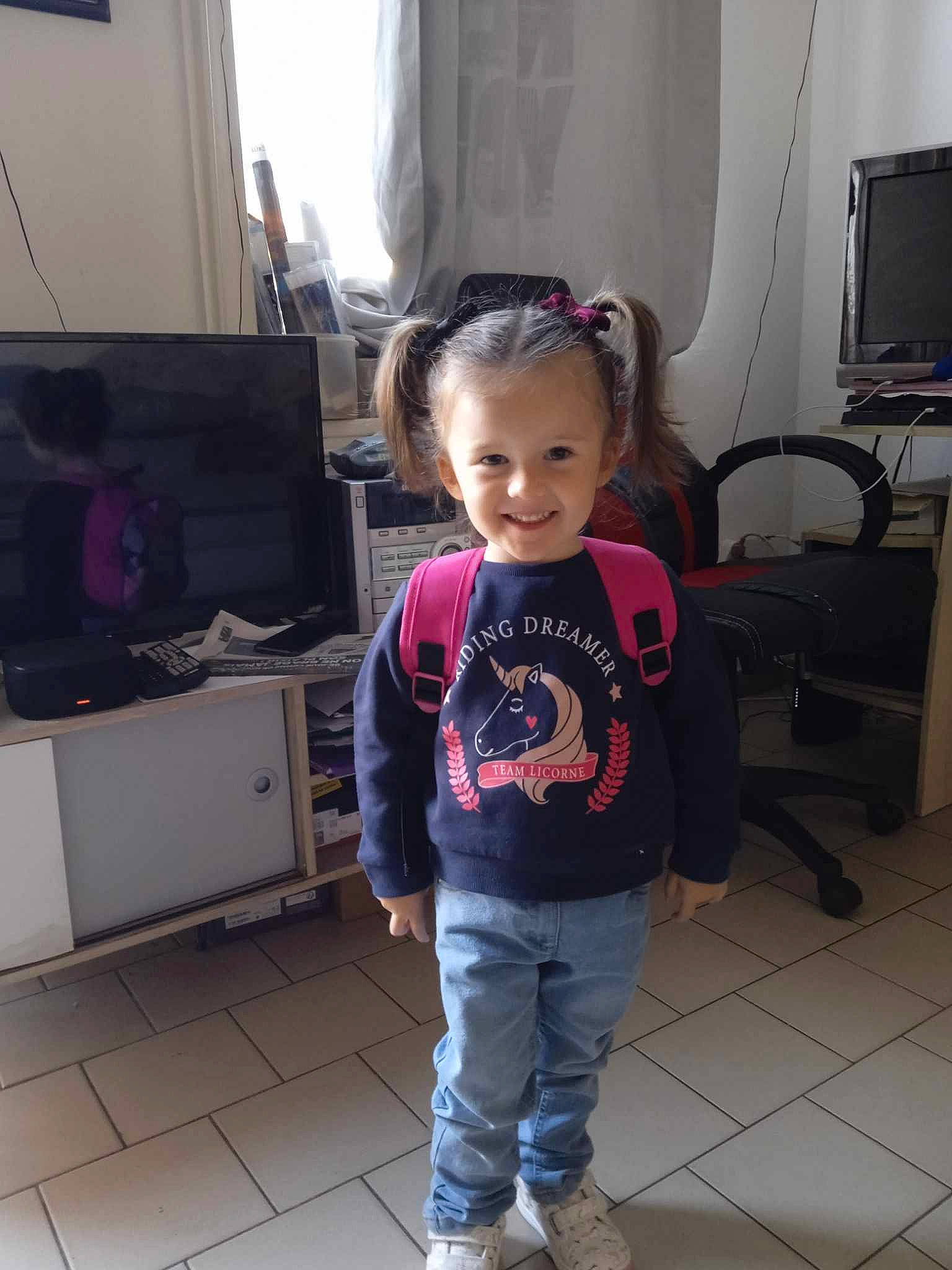 Inaya a rejoint le concours — aidez-le/la à gagner de superbes lots ! audio_equipment, baby_toddler_clothing, child, computer_monitor, curtain, display_device, floor, flooring, fun, hardwood, home_appliance, joint, joy, person, room, shoulder, sleeve, standing, t_shirt, television