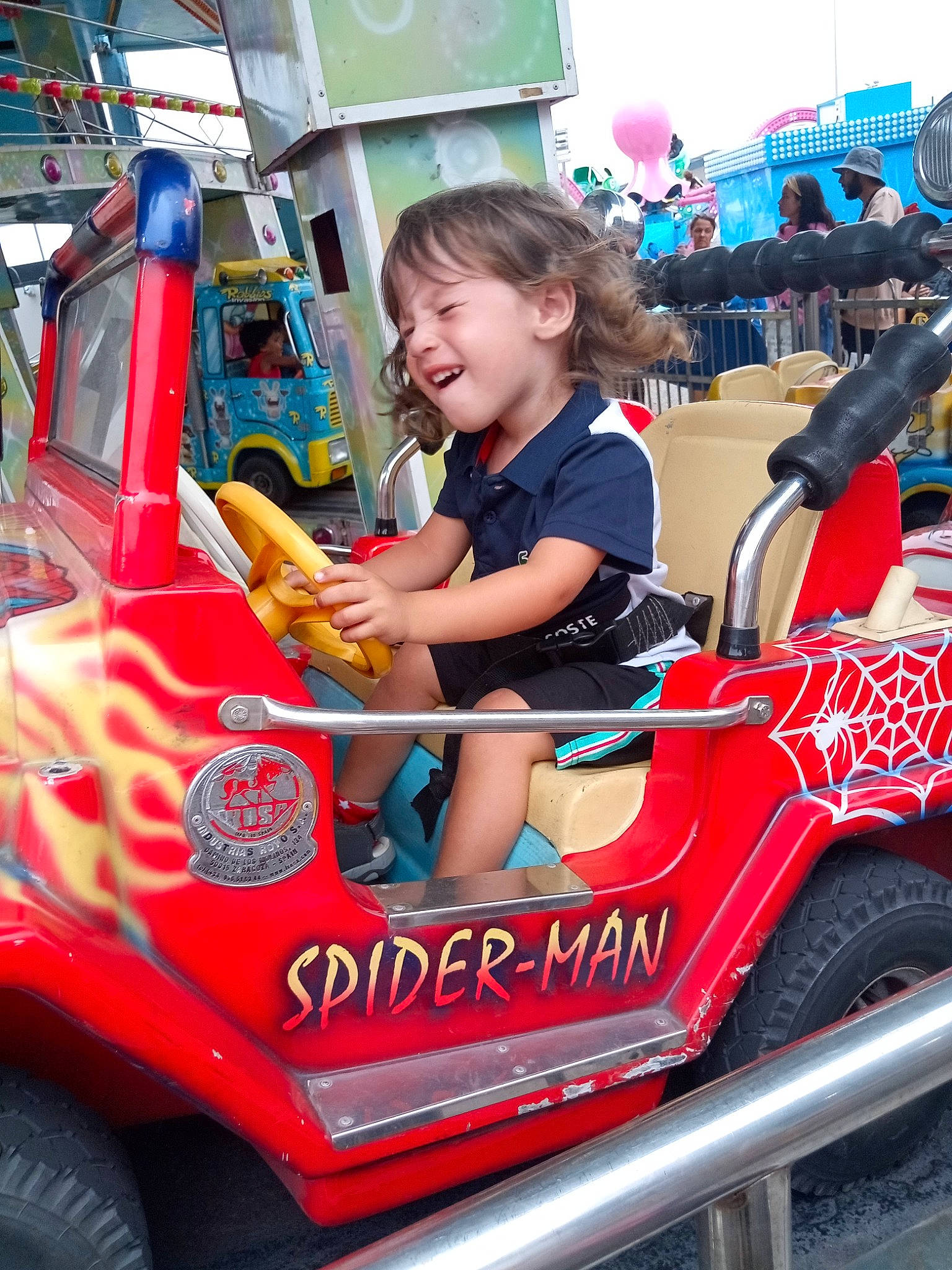 Marwan participe au concours pour gagner de l'argent avec cette photo : auto_part, automotive_design, automotive_exterior, automotive_tire, automotive_wheel_system, blurred, bumper, hand, leisure, mode_of_transport, motor_vehicle, person, recreation, riding_toy, shorts, smile, t_shirt, tire, toddler, truck