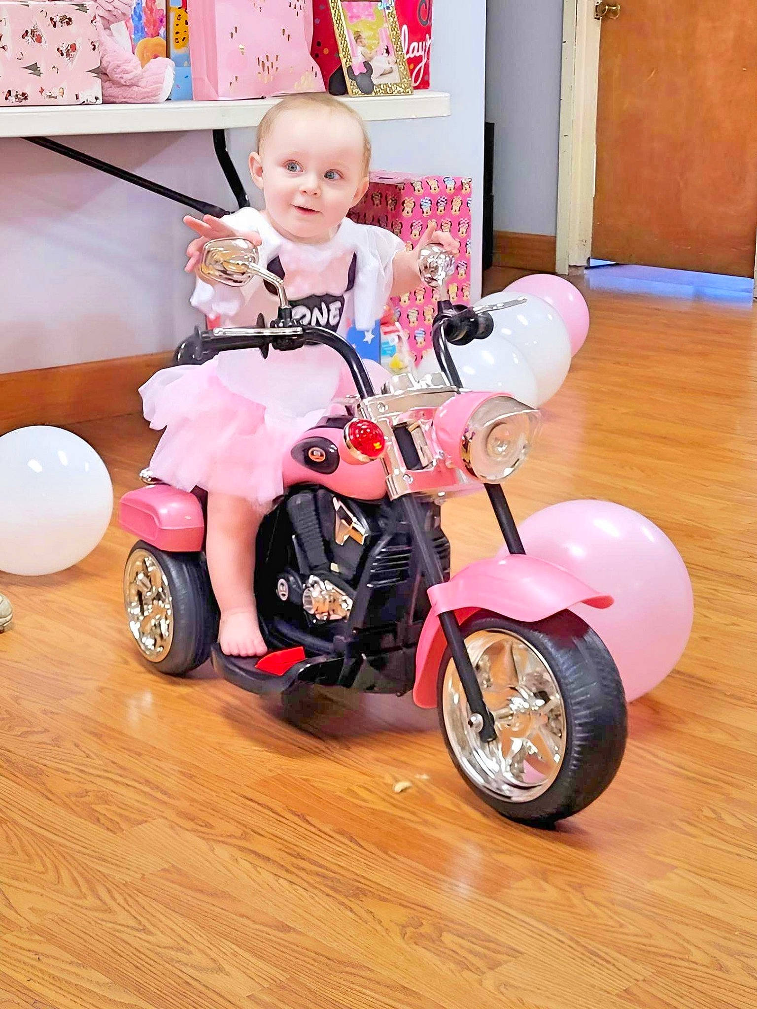 Koda is registered to the contest to win money with this photo: automotive_design, automotive_tire, automotive_wheel_system, baby, baby_toddler_clothing, bicycle, fender, happy, joy, leg, motor_vehicle, person, pink, riding_toy, rim, rolling, sneakers, tire, toddler, toy