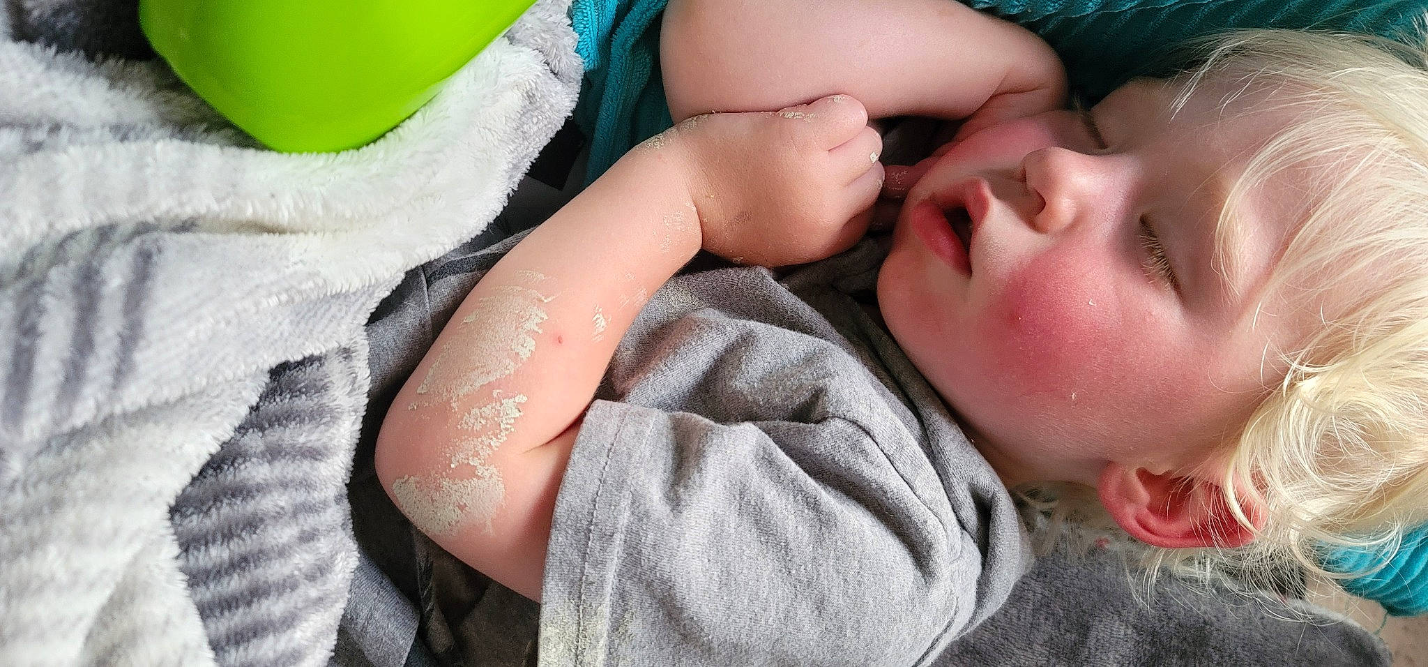 Alaric is registered to the contest to win money with this photo: baby, blue, cheek, child, comfort, eye, eyelash, finger, gesture, green, happy, linens, lip, mouth, neck, nose, person, skin, textile, toddler