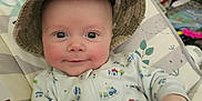 Ethan is registered to the contest to win money with this photo: baby, child, hat, onesie, smile, face, infant, cushion, seat, clothing, indoor, hand, pattern, toy, furniture, person, cute, expression, relaxing, baby_seat