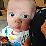 Ethan joined the competition — help win amazing prizes! baby, infant, face, eyes, onesie, dinosaur_pattern, curious, expression, skin, child, portrait, closeup, indoor, person, young_child, cute, human, apparel, sitting, holding