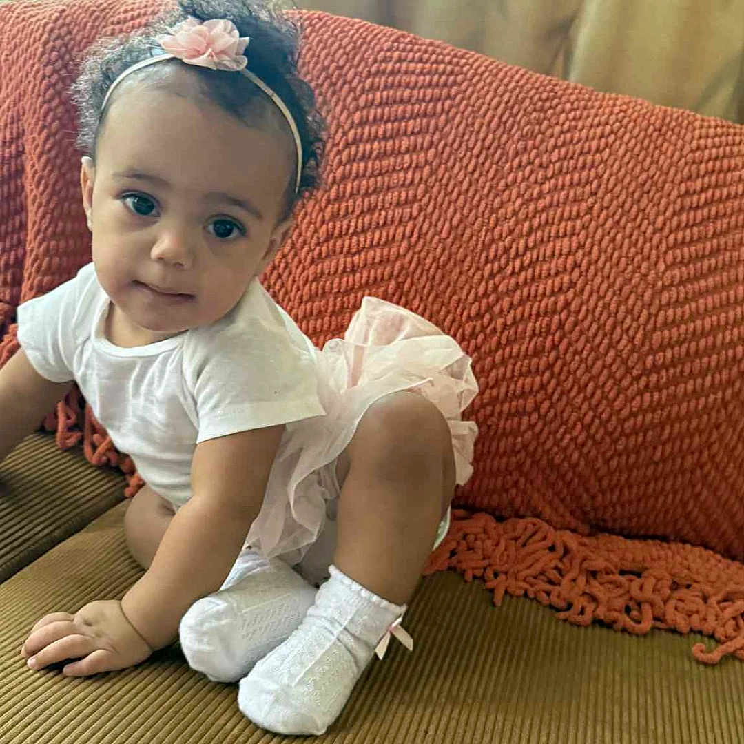 Star joined the competition — help win amazing prizes! baby, child, couch, curly_hair, curtains, cute, flower, furniture, headband, indoor, orange_blanket, person, pink_tutu, playful, portrait, smiling, toddler, white_shirt, white_socks, window