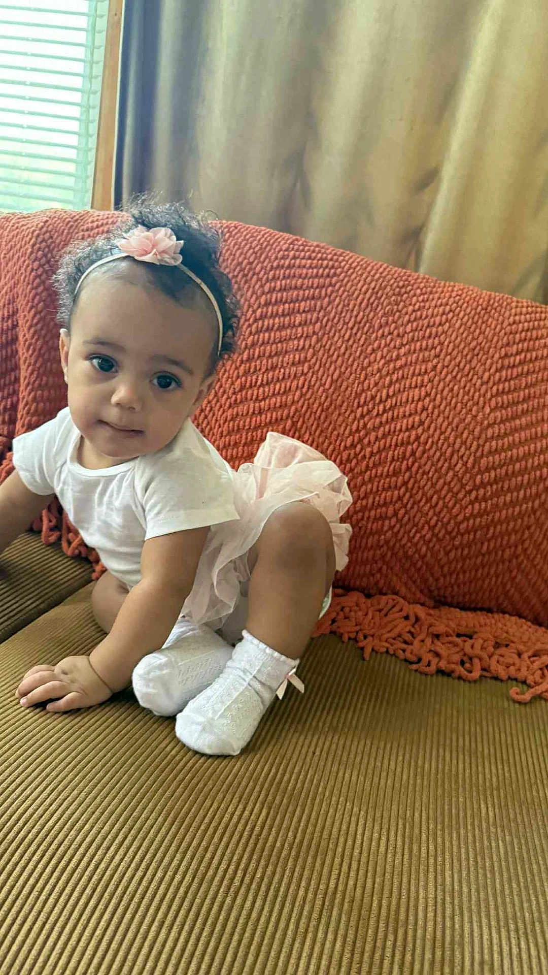 Star joined the competition — help win amazing prizes! toddler, child, baby, headband, flower, white_socks, white_shirt, pink_tutu, couch, orange_blanket, curly_hair, indoor, window, curtains, playful, smiling, portrait, cute, person, furniture