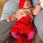 Inäya participe au concours pour gagner de l'argent avec cette photo : baby, sleeping, red_clothing, pink_clothing, headband, flower_accessory, pillow, star_pattern, indoors, blanket, soft_fabric, child, cute, toddler, footwear, floor, cozy, resting, infant, comfort