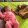 Inäya a rejoint le concours — aidez-le/la à gagner de superbes lots ! baby, bed, blanket, cat, child, cozy, curious, cute, domestic_animal, furniture, green_bedspread, indoor, infant, interaction, lying_down, pet, pink_clothing, relaxed, sleepwear, tabby_cat