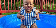 Leilani joined the competition — help win amazing prizes! baby, blue_pool, child, cute, deck, fun, greenery, happy, infant, outdoor, play, portrait, sitting, smiling, striped_clothing, summer, sunny_day, swimsuit, water, wooden_railings
