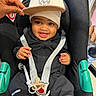 Raheem participe au concours pour gagner de l'argent avec cette photo : baby, car_seat, child, smiling, hat, hand, black_clothing, pacifier, seatbelt, happy, infant, cute, indoors, person, toddler, playful, jacket, accessory, safety, seat