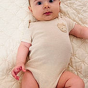 Mustafo is registered to the contest to win money with this photo: baby, infant, child, onesie, striped_clothing, quilted_blanket, laying_down, chubby_arms, chubby_legs, curious_expression, wide_eyes, indoor, soft_lighting, cute, portrait, skin, head, hand, foot, person