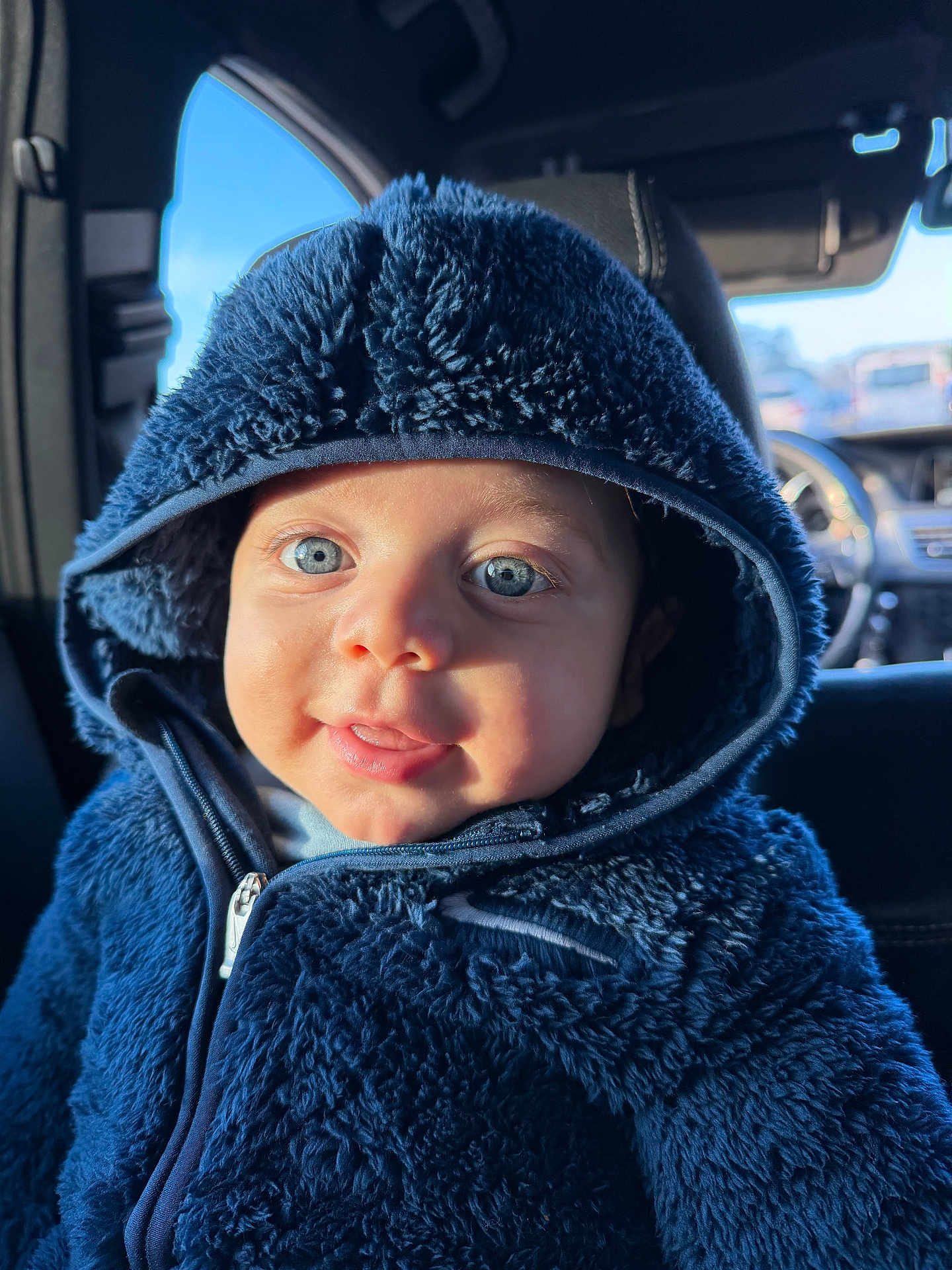 Ilia a rejoint le concours — aidez-le/la à gagner de superbes lots ! baby, child, blue_eyes, hood, jacket, fuzzy_clothing, car_interior, seat, portrait, cute, smile, young_child, warm_clothing, closeup, infant, person, cozy, sunlight, face, happy