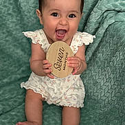 Leilani joined the competition — help win amazing prizes! baby, infant, smile, happy, seven_months, plaque, wooden_sign, cute, sitting, clothing, blanket, texture, portrait, child, young, celebration, milestone, hands, feet, indoors
